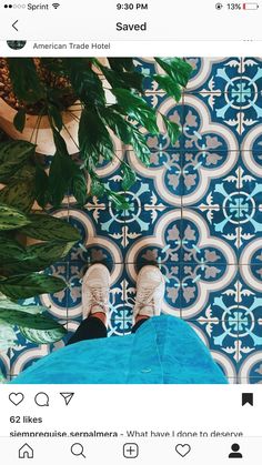 someone standing in front of a blue and white tile wall with their feet on the ground