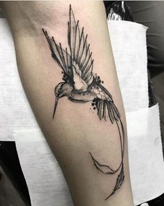 a black and white bird tattoo on the arm