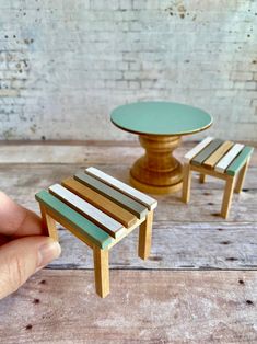 a miniature table and stool made out of wooden planks, with a small green top