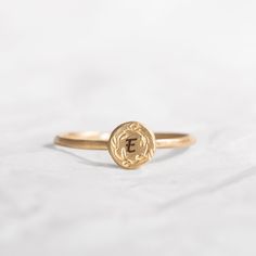 This gorgeous Solid 14K custom initial ring, is engraved with dainty handmade floral decoration. A special gift ring to cherish for many years to come, the top gold disk is engraved with a single letter but you choose to engrave any other word in the following link: https://etsy.me/2HCG2W2 A perfect gift idea for your graduation or birthday gift. Band width: 1.2 mm / 0.05' Inch, band thickness: 0.8 mm / 0.03' Inch Top ring diameter 6 mm / 0.24' Inch *Each extra letter cost $2 - Please add the at Dainty Engraved 14k Yellow Gold Ring, Dainty Engraved Yellow Gold Ring Stamped 14k, 14k Gold Dainty Engraved Ring, 14k Gold Engraved Ring With Initials, Dainty Recycled Gold Signet Ring For Anniversary, Stackable Yellow Gold Rings With Initials, Yellow Gold Initial Ring With Monogram, Dainty Yellow Gold Ring With Engraving Option, Dainty Yellow Gold Engraved Ring