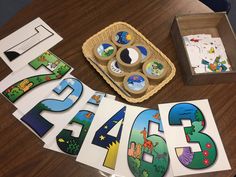 a wooden table topped with lots of magnets next to a box filled with magnets