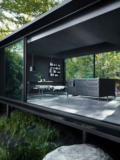 an open living room and dining area with glass walls