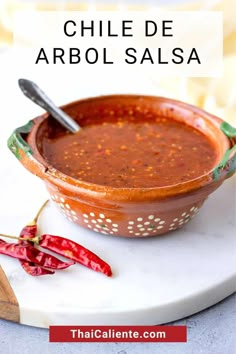 a bowl of chili sauce on a plate with the words chile de arbol salsa