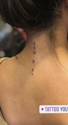 the back of a woman's neck with roman numerals on her left side