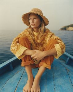 a woman sitting on top of a blue boat