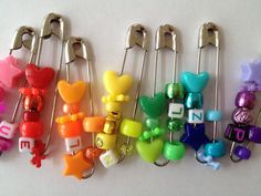 there are many different colored plastic animals on these clip holders with name tags attached to them