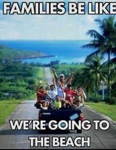 a group of people riding in the back of a truck down a road with palm trees