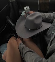 a person sitting in the back seat of a car with a hat on their head