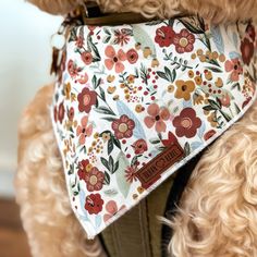 a dog wearing a bandana with flowers on it