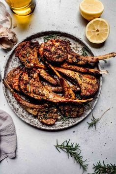 grilled chicken on a platter with lemons and herbs