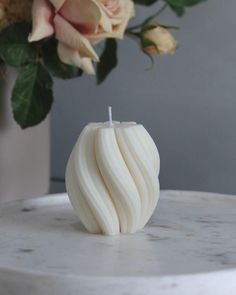 a white candle sitting on top of a marble table