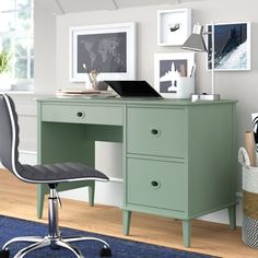 a green desk and chair in a room with pictures on the wall above it, next to a blue rug