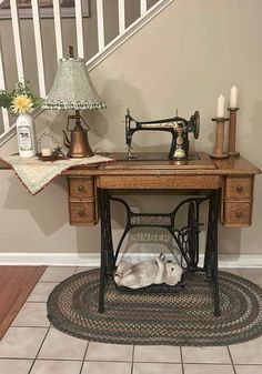 a sewing machine sitting on top of a wooden table next to a lamp and rug