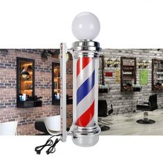 a barber pole with a red, white and blue striped design on it in front of a brick wall