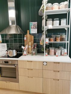 a kitchen with wooden cabinets and shelves filled with various items on the counter top next to an oven