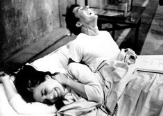 a woman laying on top of a bed next to a man