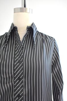 "Description: 1970s black and white striped silky polyester blouse. Long sleeves with pleated shoulders. Button front. Condition: In great condition, with no holes or stains. Designer: It's Gailord Stated Size: 10 Measurements: Armpit to armpit: 18\" Shoulder to shoulder: 14.5\" Sleeve length: 23\" Overall length: 23\" Waist: up to 35\" ---> If you need an order shipped by a particular date or shipped via a quicker method, please ask PRIOR to purchase to see if we can accommodate that request Retro Black Button-up Blouse, Black Long Sleeve Blouse With Vertical Stripes, Classic Black Shirt With Vertical Stripes, Black Collared Blouse With Striped Collar, Classic Formal Blouse With Striped Collar, Black Blouse With Striped Collar, Black Formal Top With Striped Collar, Formal Black Top With Striped Collar, Elegant Pinstripe Blouse For Formal Occasions