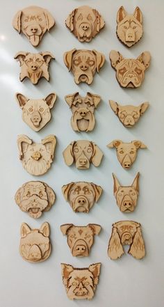 wooden cutouts of dogs and cats are displayed on a white surface, including one dog's head