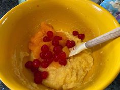 a yellow bowl filled with food and a wooden spoon in the bowl next to it