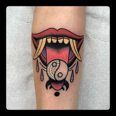 a woman's leg with an open mouth and yin - yang tattoo on it