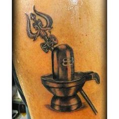 a tattoo on the back of a man's leg with an image of a coffee grinder