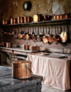 an old kitchen with pots and pans hanging on the wall