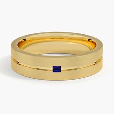 a yellow gold wedding band with a blue sapphire stone in the center, set against a plain white background