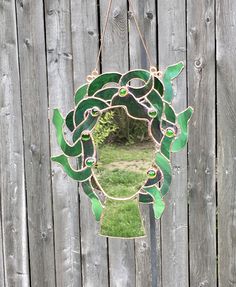 a mirror hanging on the side of a wooden fence