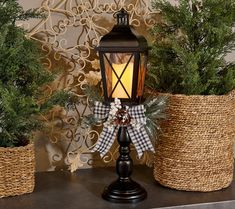 a lantern sitting on top of a table next to some baskets filled with pine trees