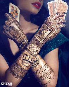 a woman is holding up some cards in her hands with hendi designs on it