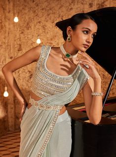 Elevate your style with this aqua drape sari, showcasing intricate embroidery on the sari border. The fully embroidered blouse steals the spotlight, and the outfit is both padded and secured with a hook-eye closure on the back, ensuring a perfect fit. Embrace the grace and charm of this ensemble, where every detail is thoughtfully crafted for a timeless appeal. Sleeveless Pre-draped Saree With Resham Embroidery For Party, Georgette Tops With Traditional Drape And Dupatta, Designer Embellished Sleeveless Pre-draped Saree, Fitted Pre-draped Saree With Intricate Embroidery For Festivals, Sleeveless Pre-draped Saree With Intricate Embroidery For Reception, Party Side Open Pre-draped Saree With Resham Embroidery, Festive Draped Blouse For Party Wear, Festive Sleeveless Saree With Intricate Embroidery, Festive Pre-draped Sleeveless Saree With Intricate Embroidery