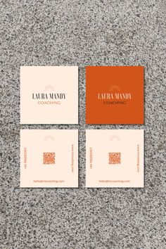 three business cards sitting on top of a gray surface with an orange and white logo