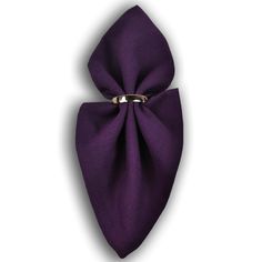 a purple bow tie on top of a white surface with a silver ring in the middle