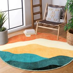 a living room with a chair, rug and potted plant on the hardwood floor