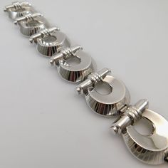 Vintage wide Etruscan revival bracelet is a substantial Monet bracelet, circa 1940. This silver tone statement bracelet has a push in box clasp with a MONET hang tag and safety chain. Clasp is also signed MONET. Bracelet measures 1 1/6 inch wide and 7 inches wide. Bracelet is in excellenting vintage condition - tongue to box clasp shows plating wear and the safety chain shows some discoloration. Any dark spots in pictures are glare - the silver tone metal is beautiful and shiny. Amazing statemen Formal Metal Chain Bracelet With Clasp, Metal Chain Bracelet With Clasp For Formal Occasions, Vintage Formal Chain Bracelet With Box Clasp, Formal Metal Bracelets With Clasp, Vintage Formal Chain Bracelet With Polished Finish, Vintage Polished Chain Bracelet For Formal Occasions, Silver Retro Metal Bracelets, Retro Silver Metal Bracelets, Modern Silver Bracelets With Clasp