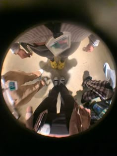 a group of people standing around each other with their feet on the ground looking up