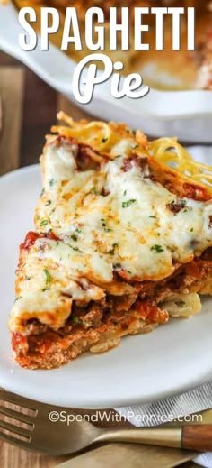 two white plates topped with lasagna and spaghetti pie next to silverware on a wooden table