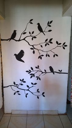 the wall is decorated with black birds on branches