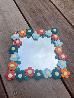 a flower shaped mirror sitting on top of a wooden table