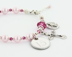 "A dazzling First Holy Communion bracelet, Confirmation bracelet, or Quinceanera bracelet. The pretty in pink Rosary bracelet has 10 pearls to represent the Hail Mary beads and one larger crystal as the Our Father bead. It comes with a Crucifix and a Miraculous Medal dangling near the clasp. It is available with or without an Engraved Disc and it comes with your choice of a Gift Message that is elegantly boxed for simple gift giving. Add an Engraved Disc - Select a Disc option. - Select a Disc D Cheap Pink Rosary Bracelet For Gift, Elegant Adjustable Rosary Bracelet For Birthday, Elegant Pink Bracelets For First Communion, Adjustable Pink Bracelets For Anniversary, Personalized Rosary Bracelet For Birthday, Quinceanera Bracelet, Pink Rosary, Bracelet Rosary, Quinceanera Gifts