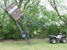 an atv being pulled by a truck with a ladder attached to the back of it