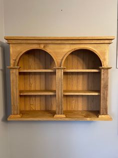 an old wooden bookcase with two arched doors on the front and back shelves above it