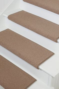 three beige carpeted steps leading up to a white door