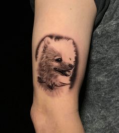 a small tattoo on the arm of a person with a dog's head in it