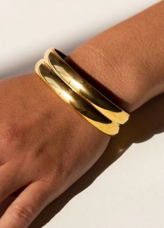 A stunning gold-plated, highly polished bracelet cuff inspired by the mesmerizing beauty of ocean waves. The intricate detailing and smooth finish of this piece make it a perfect addition to any jewelry collection. The plating ensures a long-lasting shine, giving you a luxurious look that will last for years to come. Whether you're dressing up for a special occasion or adding a touch of elegance to your everyday look, this bracelet cuff is sure to make a statement.Material: 18 Karat Gold Plated