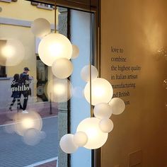 a light fixture hanging from the side of a glass window in front of a building