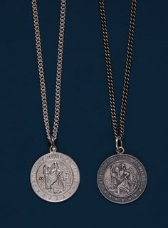 two silver necklaces with an image of people on them