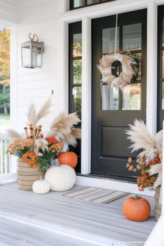 fall front porch decor with pumpkins and pamylons