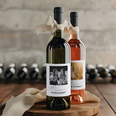 two bottles of wine sitting on top of a wooden table