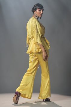 Daffodil organza silk pant with flared hem, comes with bustier. Paired with double collar embroidered peplum top and hand braided belt.
Components:4
Pattern:Embroidered
Type of Work:Floral Motifs
Neckline:Notched Lapel Collar
Sleeve Length:Three Quarter
Fabric:Organza silk
Color:Yellow
Other Details:
Beaded sleeve details
Tie-up sleeves
Hand braided belt
Occasion:Destination Wedding - Aza Fashions Peplum Pants, Isha Gupta, Silk Pant, Double Collar, Indian Fashion Saree, Indian Dresses Traditional, Traditional Indian Outfits, Simple Pakistani Dresses, Party Wear Indian Dresses